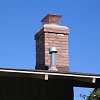 Custom Masonry Brick Chimney - close up view of chimney cap and copper spark arrestor